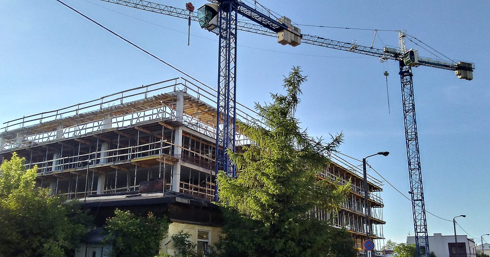 Budowa wielorodzinnego budynku mieszkalnego — dźwig nad blokiem w stanie surowym w Tomaszowie Mazowieckim